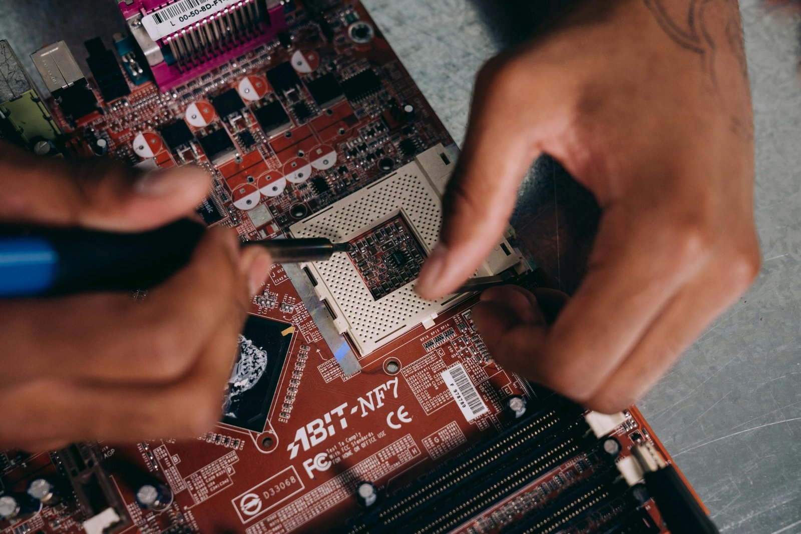 Hands intricately working on a motherboard, representing technology and precision engineering.